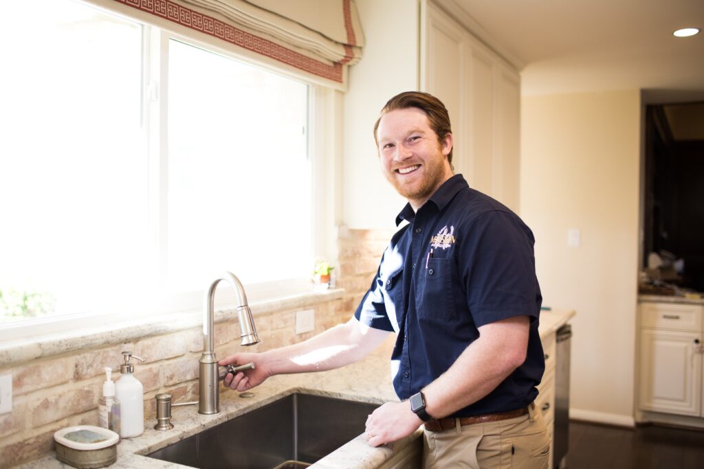 happy mission plumber performing an fixture installation on a kitchen sink in a houston texas home