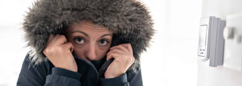 woman in warm clothing that is freezing in her house