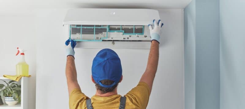 Person installing ductless air conditioner